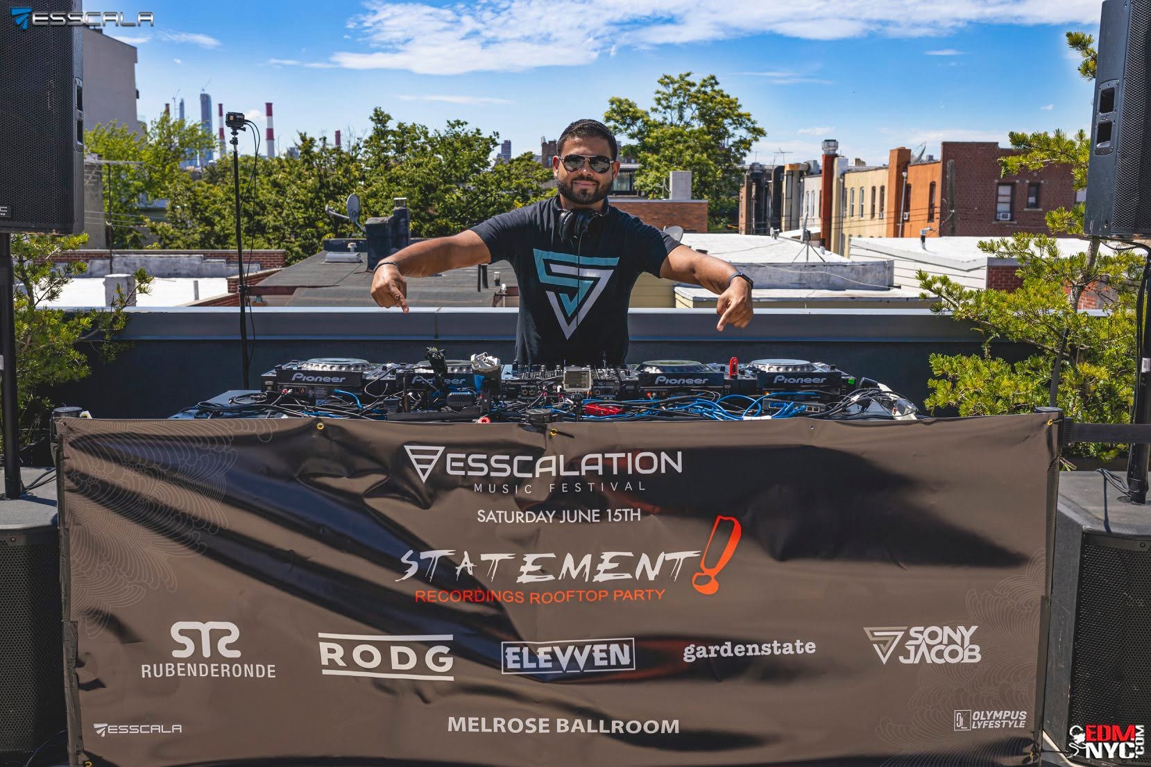 Sony Jacob at the Esscala Statement! Recordings rooftop party, with the event banner and turntables